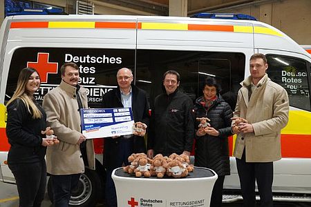 Übergabe der Kuscheltiere vor einem Krankentransportwagen